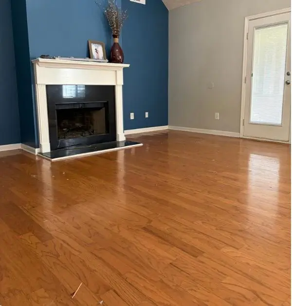 Before: the same living room with the original orange-brown floor
