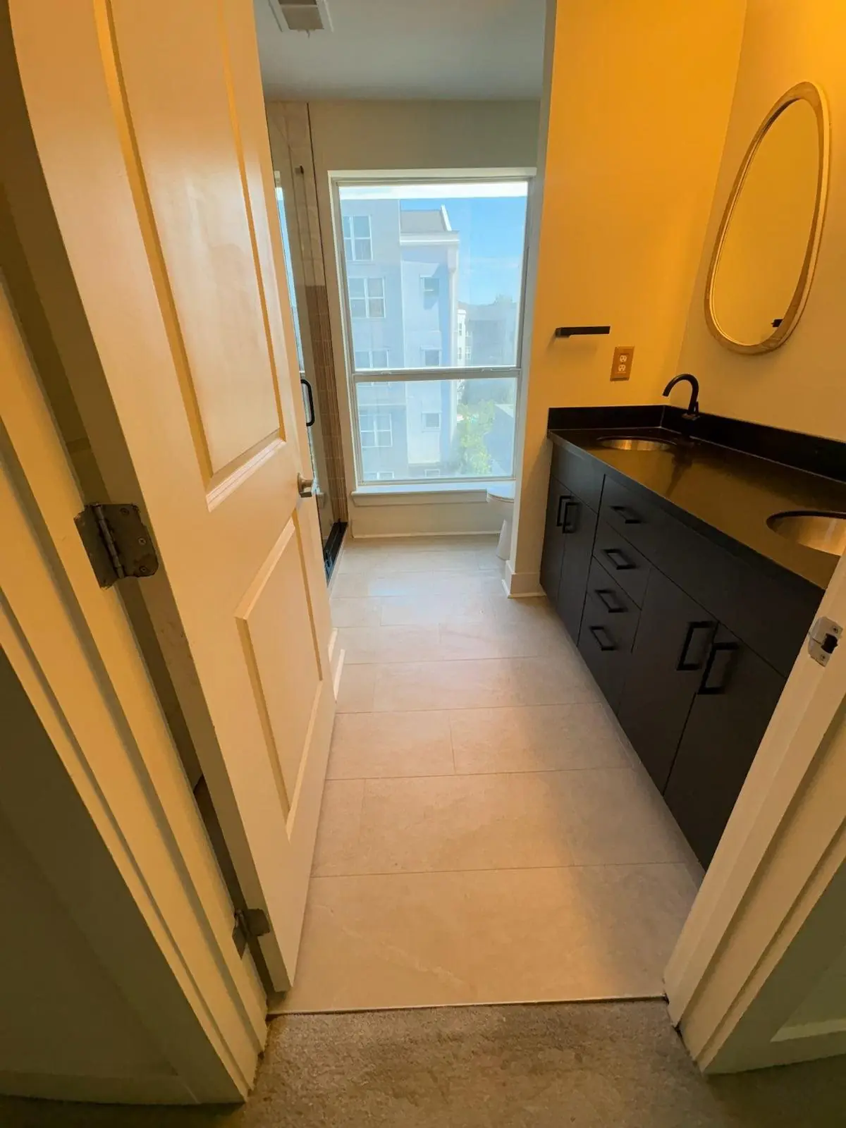 Bathroom with large-format light tile and a dark vanity