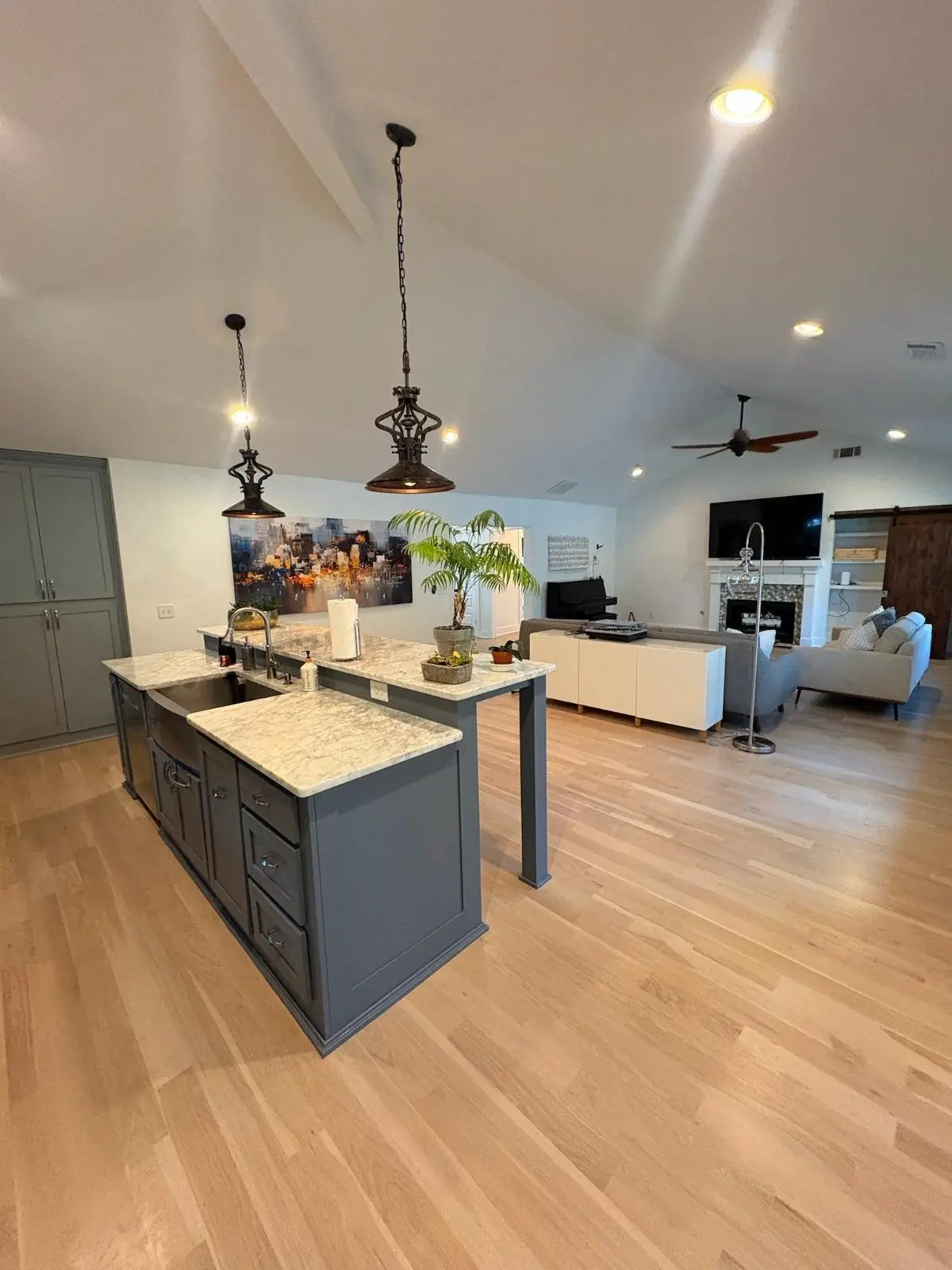 Kitchen with light wood flooring and a gray island