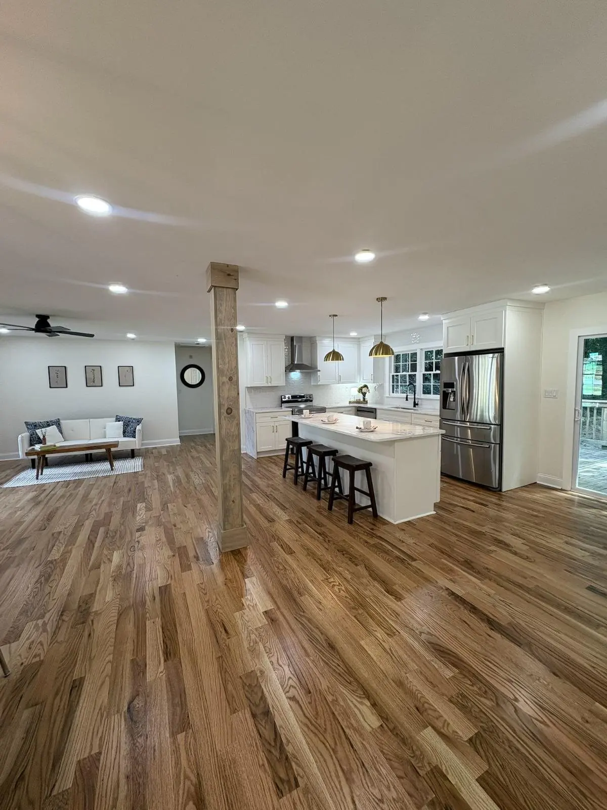 Kitchen with a white island and light wood plank flooring