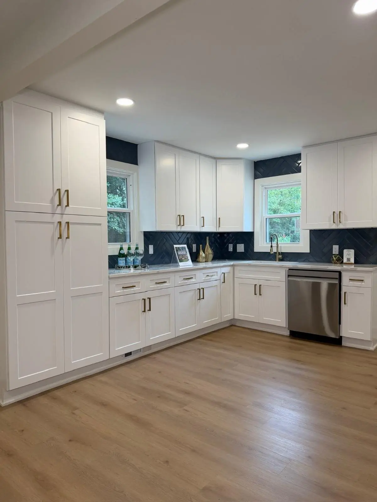 White kitchen with light wood plank flooring