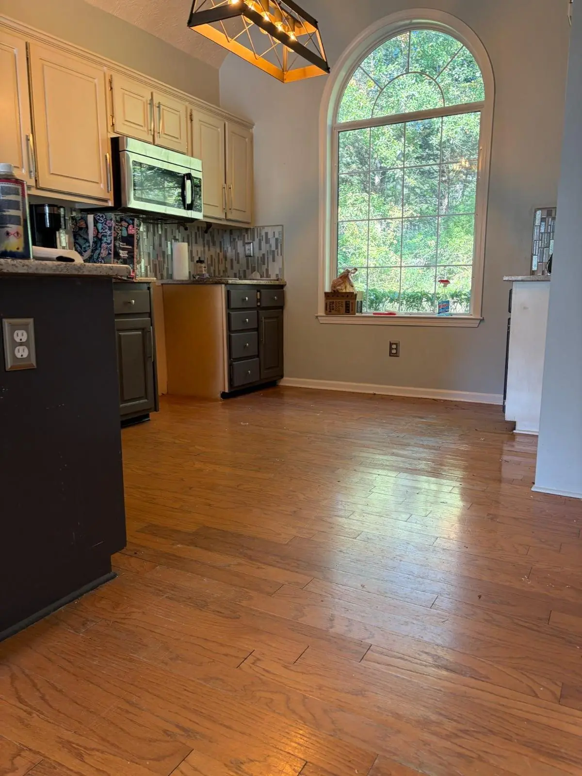 Kitchen with medium wood flooring and a window over the sink