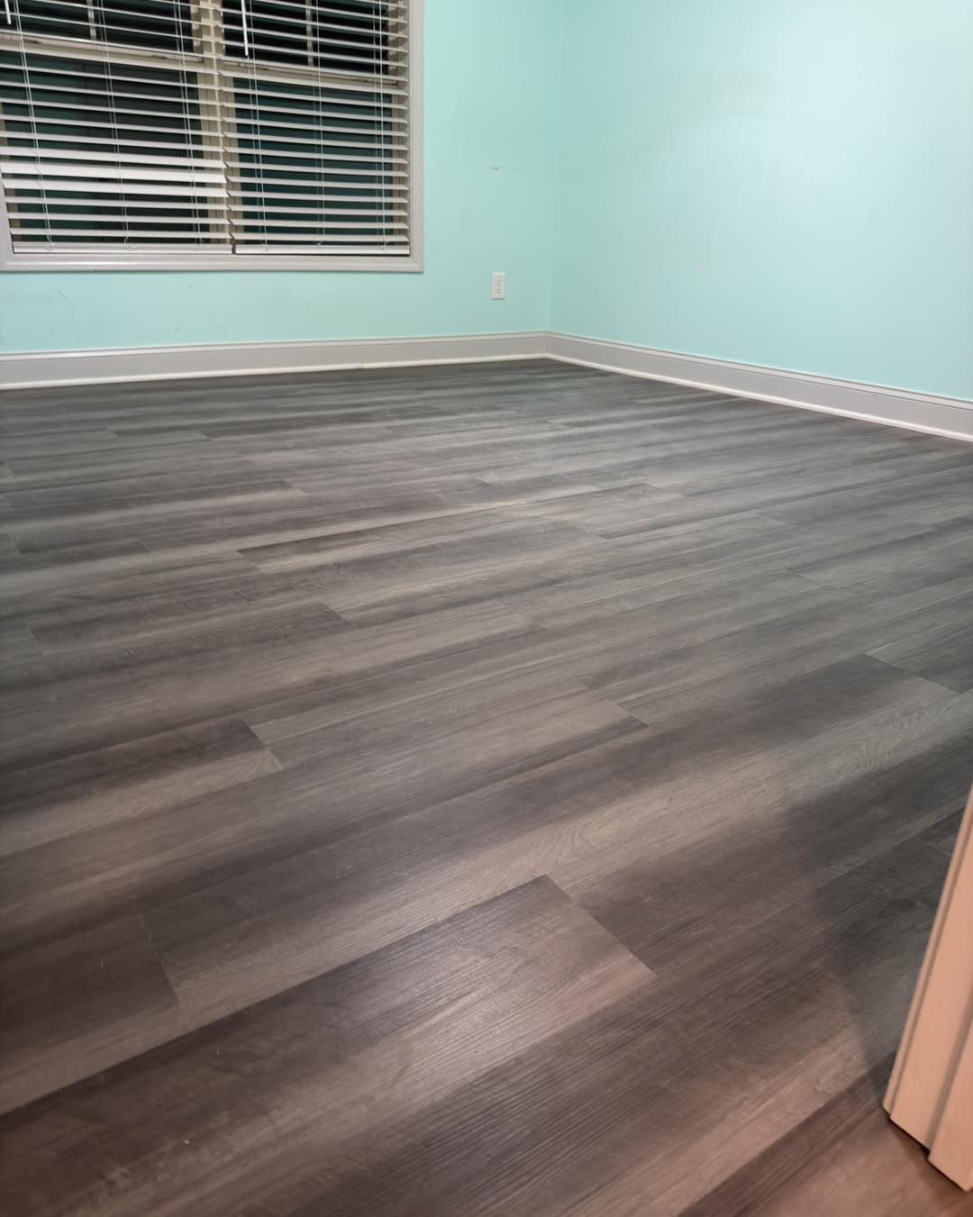 Kitchen with light wood flooring and a gray island